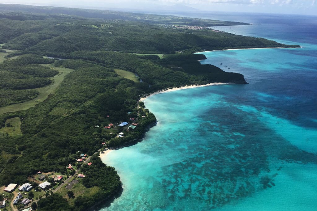 La côte de Marie-Galante vue du ciel : plages, lagon turquoise et collines boisées